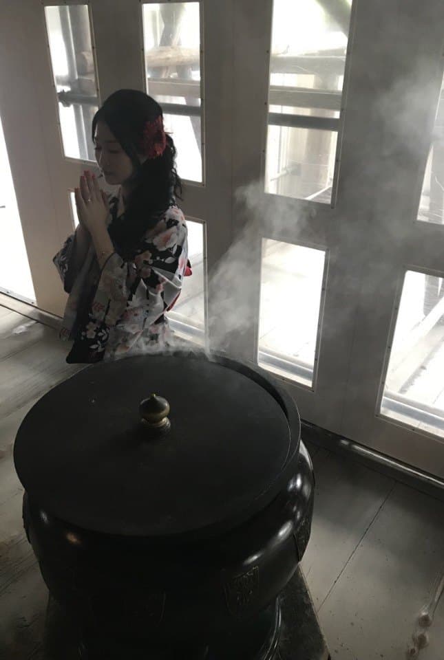 향로 앞에서 두 손을 모으고 기도하는 선생님